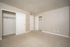Spacious bedroom with soft carpet flooring, featuring two roomy closets and a neutral color palette.