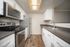Modern kitchen with sleek stainless steel appliances, elegant dark countertops, and ample white cabinetry, featuring a spacious layout for culinary creativity.