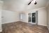 Bright and spacious living area with elegant wood flooring, large sliding doors, and ample natural light.