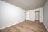 Bright and spacious bedroom with elegant wood flooring, showcasing modern white doors and ample closet space.