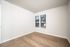 Bright and inviting room featuring elegant hardwood floors and large windows with blinds, offering a versatile blank canvas for personalization.