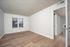 Bright and airy empty room with large windows, elegant wooden flooring, and neutral walls, ready for your personal touch.