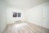 Bright, empty room with contemporary wood flooring, large window, and fresh neutral walls, perfect for personalized decor.