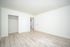 Bright and spacious bedroom with modern wood flooring and built-in closet, perfect for stylish living.