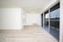 Bright living area with elegant wood flooring, large sliding glass doors, and an inviting open layout.