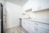 Bright and modern kitchen boasting sleek stainless steel appliances, elegant white cabinetry, and a spacious countertop design.
