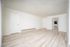 Bright and inviting living room with sleek laminate flooring, modern white walls, and ample natural light.
