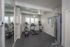Modern apartment gym featuring state-of-the-art cardio equipment, treadmill, and elliptical machine under stylish ceiling fans.