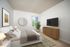 Inviting bedroom with cozy decor, featuring a large bed, stylish dresser, flat-screen TV, and serene wall art. A lush plant next to the window brings a touch of nature indoors.