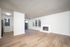 Bright and airy living space with elegant wood flooring, large windows, and a cozy fireplace, ideal for modern living.