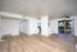 Inviting open-concept living space featuring modern wood flooring, stylish ceiling fan, and large patio doors leading to a serene balcony view.