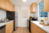 Bright and modern kitchen with natural wood cabinets, stainless steel appliances, and elegant décor elements.