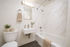 Elegant bathroom featuring a sleek white sink, modern fixtures, and luxurious marble-tiled walls.