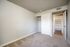 Bright and inviting bedroom with plush carpet and ample closet space, leading to a walk-in storage area.