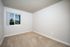 Bright, unfurnished bedroom with plush carpet and large window showcasing a serene view.
