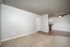 Bright and inviting living area with soft beige carpeting, sleek hardwood floors, and a modern ceiling fan, offering a perfect blend of comfort and style.