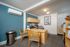 Modern office space with a wooden desk, artful blue accent wall, and elegant decor for a professional work environment.