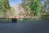 Charming outdoor space featuring a fenced area with lush greenery and trees, perfect for relaxation and leisure.