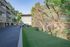 Charming apartment exterior with lush greenery and a cozy outdoor seating area, perfect for relaxation.