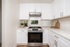 Bright, modern kitchen with sleek white cabinetry, elegant countertops, and stainless steel appliances.
