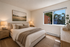 Elegant bedroom with a comfortable bed, warm lighting, and a picturesque window view, creating a serene and inviting atmosphere.