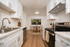 Sleek, modern kitchen and dining area featuring elegant cabinetry, stainless steel appliances, and a cozy dining nook with garden views.
