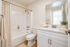 Bright and elegant bathroom featuring a modern white vanity, stylish fixtures, and a soothing neutral color palette.