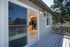 Inviting apartment patio with sliding door opening to a modern kitchen, surrounded by lush greenery.