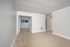 Inviting open space with plush carpet, neutral walls, and double doors leading to a bright room with a window, perfect for a cozy living area or versatile office space.