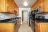 Modern kitchen with sleek stainless steel appliances, elegant wooden cabinets, and polished black countertops.