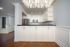 Open kitchen with white cabinets, dark countertops, stainless steel appliances, and a peninsula facing the dining area.
