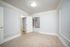 Carpeted bedroom with light gray walls, white decorative trim, and a window with blinds.