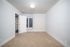 Bright and inviting bedroom with plush carpet, large window, and open closet space.