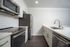 Modern kitchen with sleek stainless steel appliances, elegant white cabinetry, and polished countertops.
