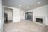 Bright and inviting living room with plush carpeting, cozy fireplace, and sliding glass doors leading to a private patio.