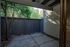Charming private patio with wooden fence and lush greenery, perfect for relaxation and outdoor enjoyment.