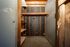 Cozy storage space featuring wooden shelves and exposed wood beams, ideal for organized living.