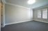 Bright and spacious room with neutral tones, large windows for natural light, and elegant crown molding.