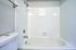 Modern bathroom with sleek white tiles and a pristine bathtub, perfect for relaxation.
