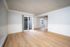 Bright and spacious living area with elegant wood flooring, sliding glass doors, and modern ceiling fan, perfect for a contemporary lifestyle.