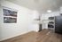 Bright modern kitchen featuring stainless steel appliances, sleek white cabinets, and large window view.