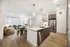 Modern open-concept apartment featuring a sleek kitchen with stainless steel appliances, cozy living area with plush seating, and elegant dining space under stylish pendant lights.
