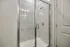 Elegant modern shower with sleek glass doors and contemporary fixtures, offering a luxurious bathing experience.