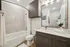 Modern bathroom featuring elegant wood cabinetry, a sleek vanity, and a stylish bathtub with a curved shower rod.