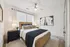 Serene bedroom with elegant decor, featuring a cozy double bed, modern nightstands, and stylish wall art.