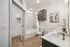 Elegant modern bathroom featuring a dual-sink vanity, sleek cabinetry, and a spacious bathtub with contemporary tile accents.