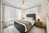 Bright and inviting bedroom with modern decor, large windows, and cozy bedding, creating a serene retreat.