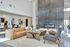 Luxurious open-concept living area with modern fireplace, chic furnishings, and ample natural light.