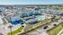Aerial view of a modern apartment complex with well-maintained green spaces, spacious parking, and a stunning central pool area, perfect for luxury living.