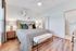 Inviting bedroom with stylish decor, featuring a cozy bed with patterned bedding, modern nightstands, and elegant wall art.